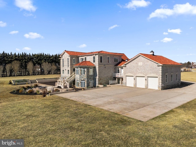 view of front facade featuring a front yard, concrete driveway, and an attached garage