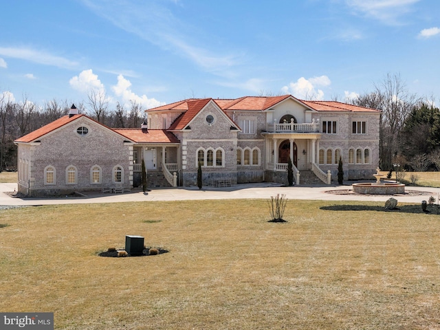 view of front of home featuring a balcony and a front lawn