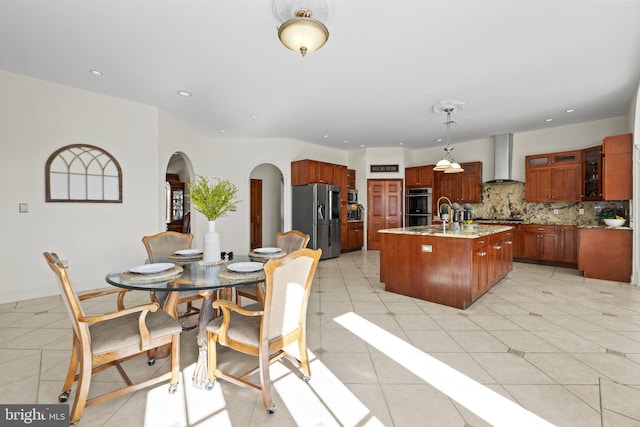 dining area with light tile patterned floors, arched walkways, and recessed lighting