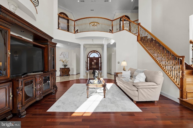 living room with stairs, baseboards, hardwood / wood-style flooring, and ornate columns