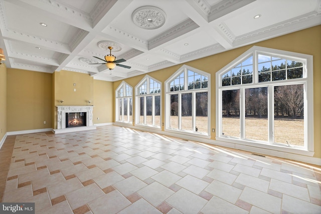 unfurnished living room with baseboards, coffered ceiling, beamed ceiling, and a glass covered fireplace