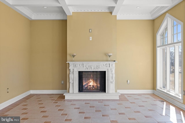 unfurnished living room with a towering ceiling, a premium fireplace, baseboards, and coffered ceiling