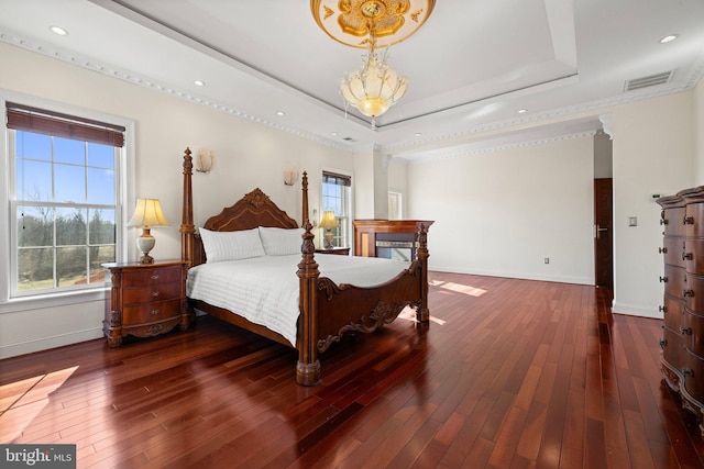 bedroom featuring baseboards, visible vents, a raised ceiling, hardwood / wood-style flooring, and recessed lighting