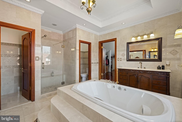 bathroom with a bath, a stall shower, tile walls, and vanity