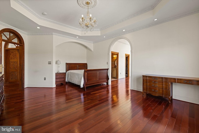 unfurnished bedroom featuring an inviting chandelier, crown molding, a raised ceiling, and hardwood / wood-style floors