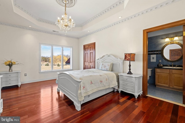 bedroom featuring dark wood-type flooring, a tray ceiling, visible vents, and a sink