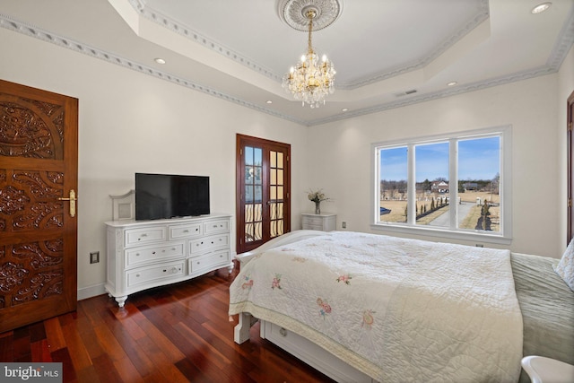 bedroom featuring visible vents, multiple windows, a tray ceiling, and dark wood-style flooring