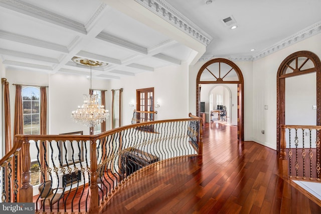 hallway featuring an inviting chandelier, an upstairs landing, coffered ceiling, beamed ceiling, and hardwood / wood-style flooring