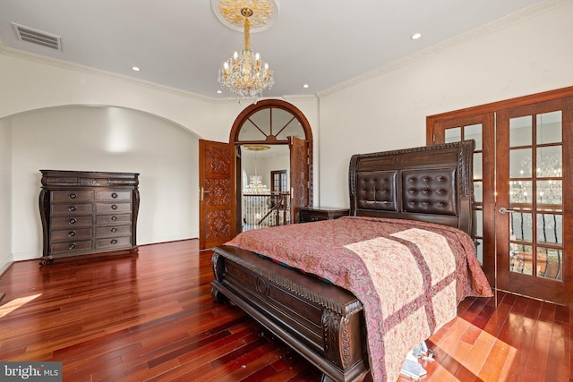 bedroom with visible vents, ornamental molding, hardwood / wood-style floors, an inviting chandelier, and french doors