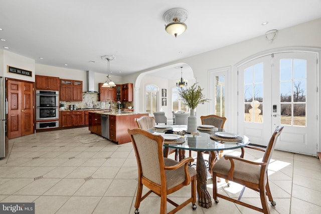 dining room with light tile patterned floors, arched walkways, and recessed lighting