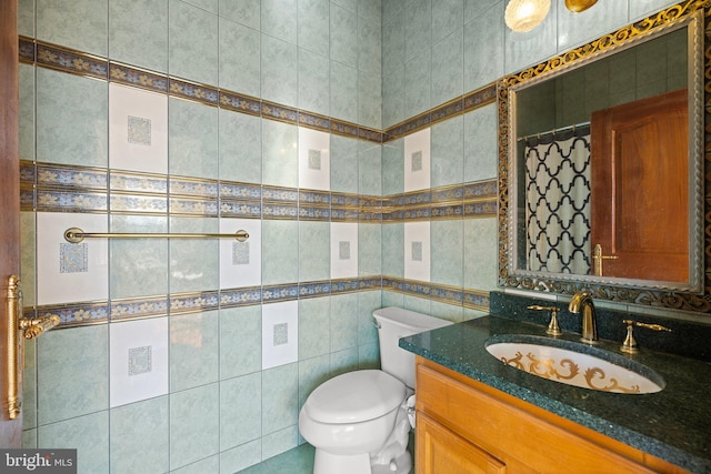 bathroom featuring toilet, vanity, and tile walls