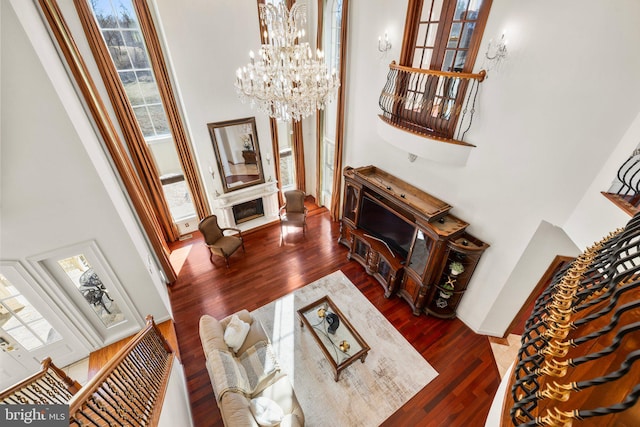 living area featuring a notable chandelier, stairway, and wood finished floors