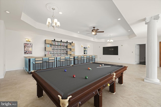 playroom featuring recessed lighting, ceiling fan with notable chandelier, indoor bar, a tray ceiling, and decorative columns