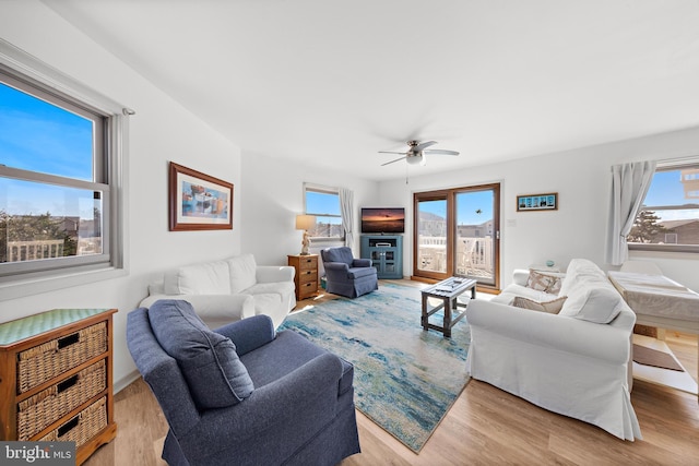 living room featuring ceiling fan, a wealth of natural light, and light wood-type flooring