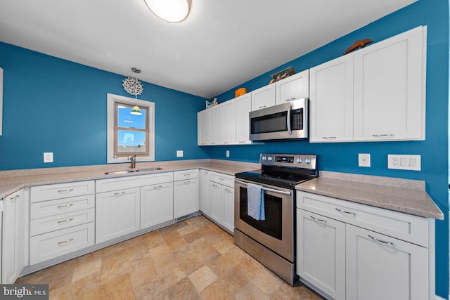 kitchen featuring white cabinetry, stainless steel appliances, sink, and hanging light fixtures