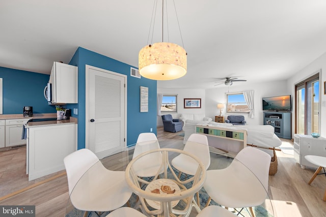 dining area with light hardwood / wood-style flooring and ceiling fan