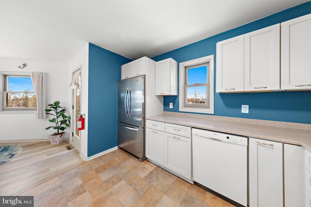 kitchen with light hardwood / wood-style flooring, stainless steel fridge, white cabinets, and white dishwasher