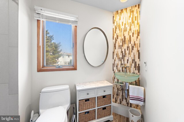 bathroom featuring toilet, hardwood / wood-style floors, and sink