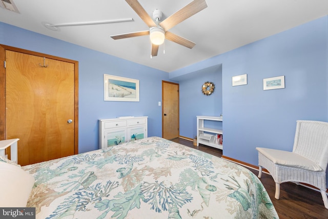 bedroom featuring a closet, dark hardwood / wood-style floors, and ceiling fan