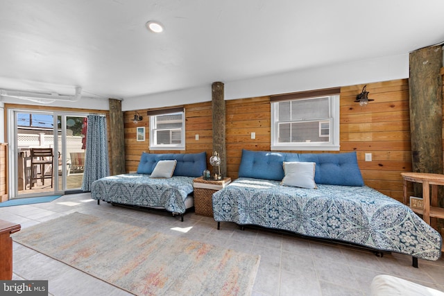 bedroom featuring access to outside and wooden walls