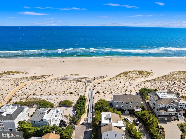 drone / aerial view with a water view and a beach view