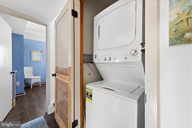 clothes washing area featuring stacked washer / drying machine and dark hardwood / wood-style floors