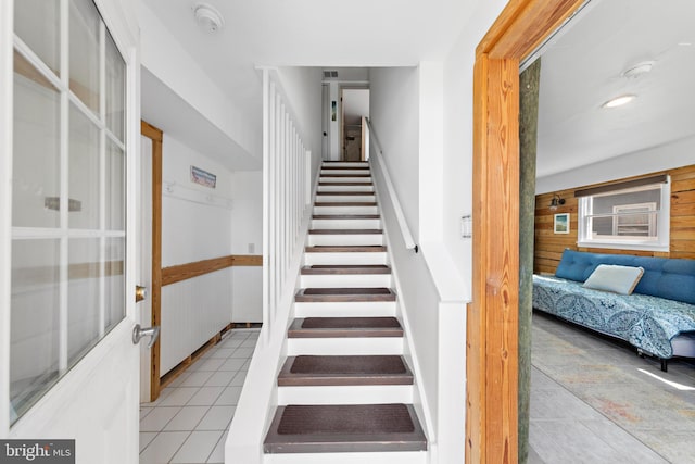 staircase featuring wood walls