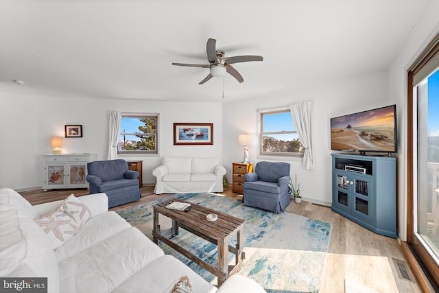 living room with light hardwood / wood-style floors, plenty of natural light, and ceiling fan