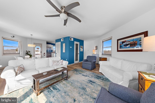 living room featuring a healthy amount of sunlight, wood-type flooring, and ceiling fan