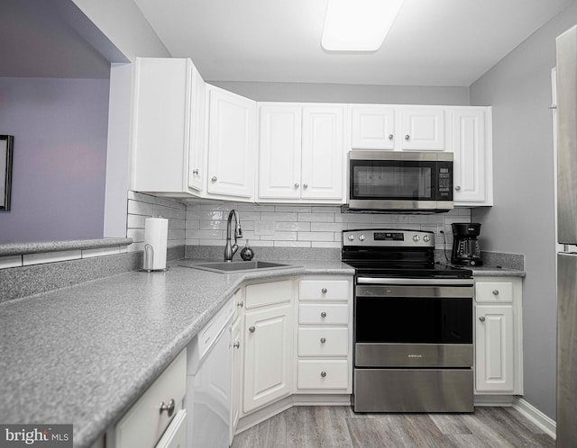 kitchen featuring stainless steel appliances, light hardwood / wood-style flooring, white cabinets, and sink