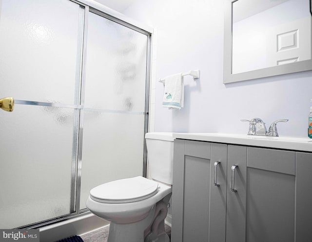 bathroom featuring an enclosed shower, toilet, and vanity