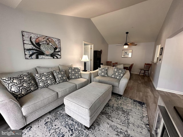 living room with hardwood / wood-style flooring, ceiling fan, and vaulted ceiling