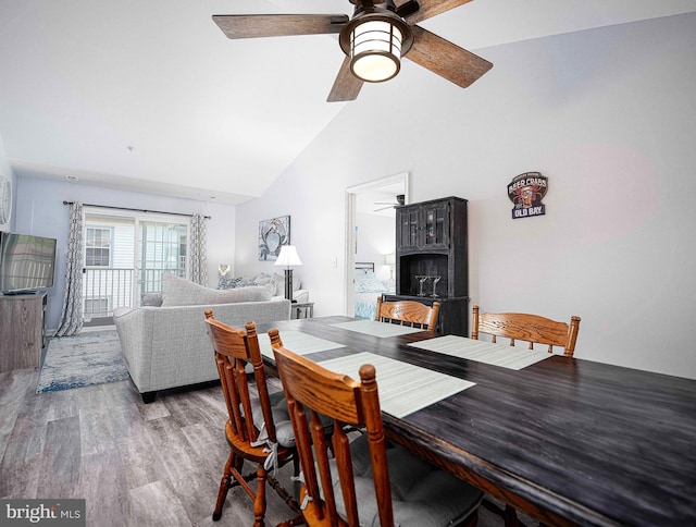 dining area with wood-type flooring, high vaulted ceiling, and ceiling fan