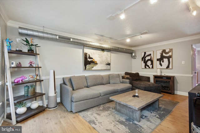 living room with ornamental molding, hardwood / wood-style floors, a textured ceiling, and rail lighting