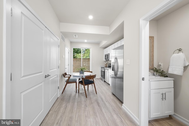 kitchen featuring white cabinetry, stainless steel appliances, and light hardwood / wood-style flooring