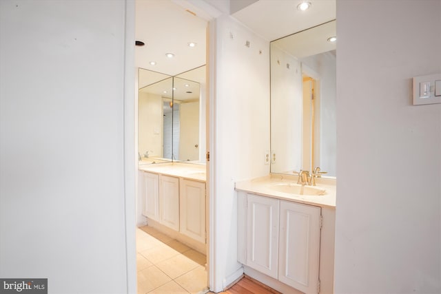 bathroom with recessed lighting, two vanities, a sink, and tile patterned floors