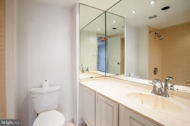 bathroom featuring toilet, a shower, vanity, and recessed lighting