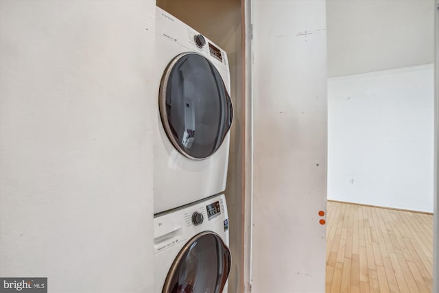 washroom featuring stacked washer / dryer and wood finished floors