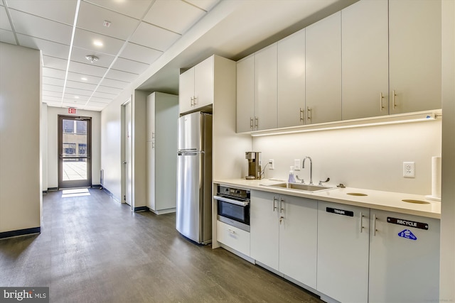 kitchen with stainless steel appliances, white cabinets, light countertops, and a sink