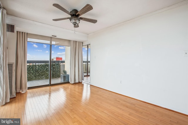 empty room featuring light wood finished floors, baseboards, a ceiling fan, and crown molding