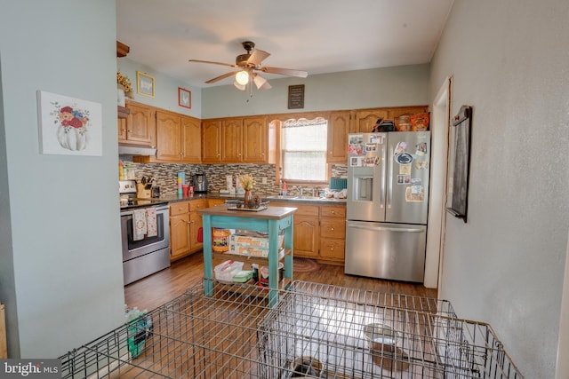 kitchen featuring backsplash, ceiling fan, dark hardwood / wood-style flooring, and stainless steel appliances