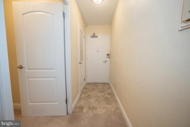 hallway featuring light colored carpet