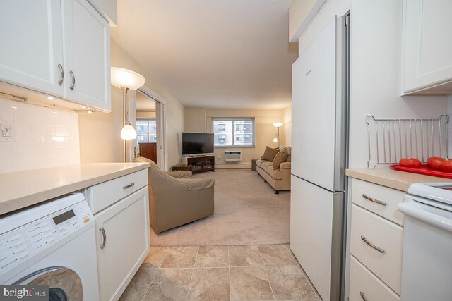 kitchen with tasteful backsplash, white appliances, pendant lighting, white cabinets, and washer / clothes dryer