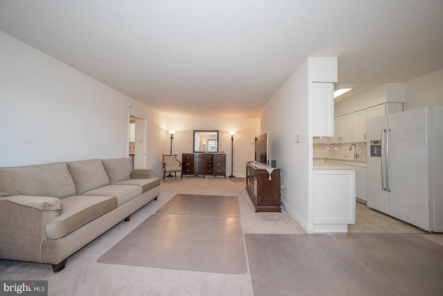 living room featuring sink and light tile patterned floors