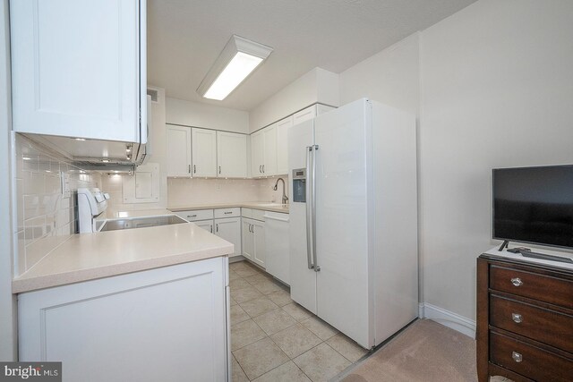 kitchen with sink, tasteful backsplash, white cabinets, white appliances, and light tile patterned floors