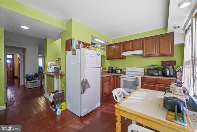 kitchen with dark wood-type flooring, white appliances, and a wealth of natural light