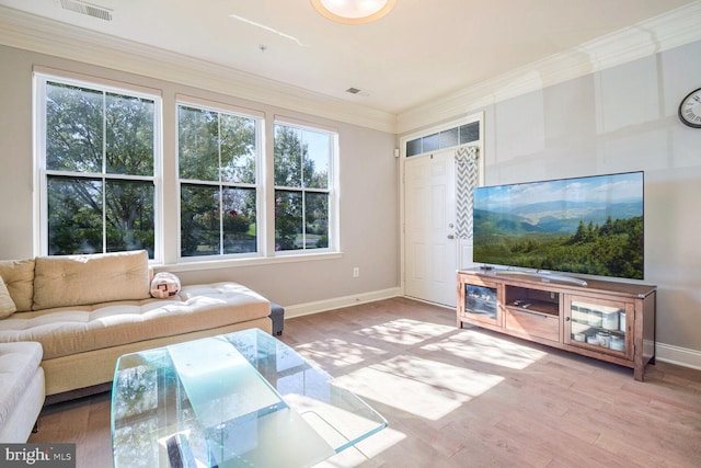 living room with a wealth of natural light, ornamental molding, and wood-type flooring