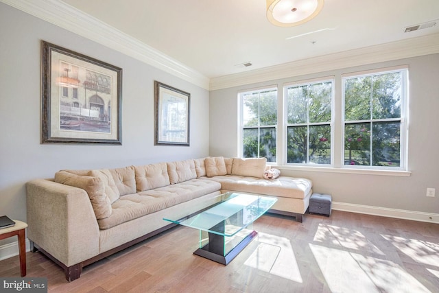 living room with crown molding, wood-type flooring, and a healthy amount of sunlight