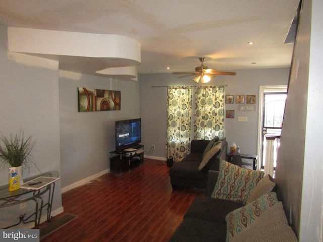 living room featuring ceiling fan and dark wood-type flooring