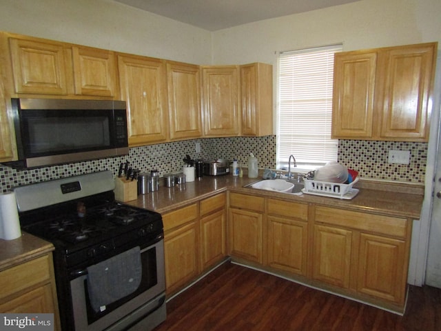 kitchen featuring appliances with stainless steel finishes, tasteful backsplash, dark hardwood / wood-style floors, and sink